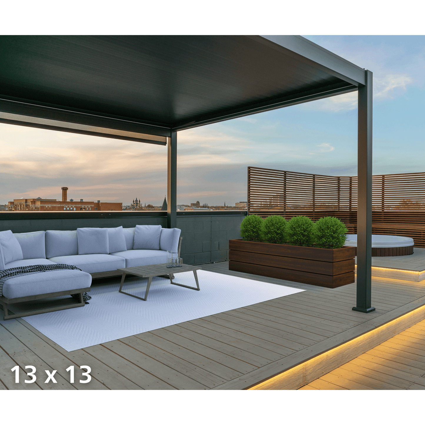The dark gray Bon Pergola features fully closed louvers, creating a solid roof. Warm yellow LED light strips run along the edges, casting a soft glow onto the wooden deck below—turning this rooftop terrace into an inviting outdoor retreat.