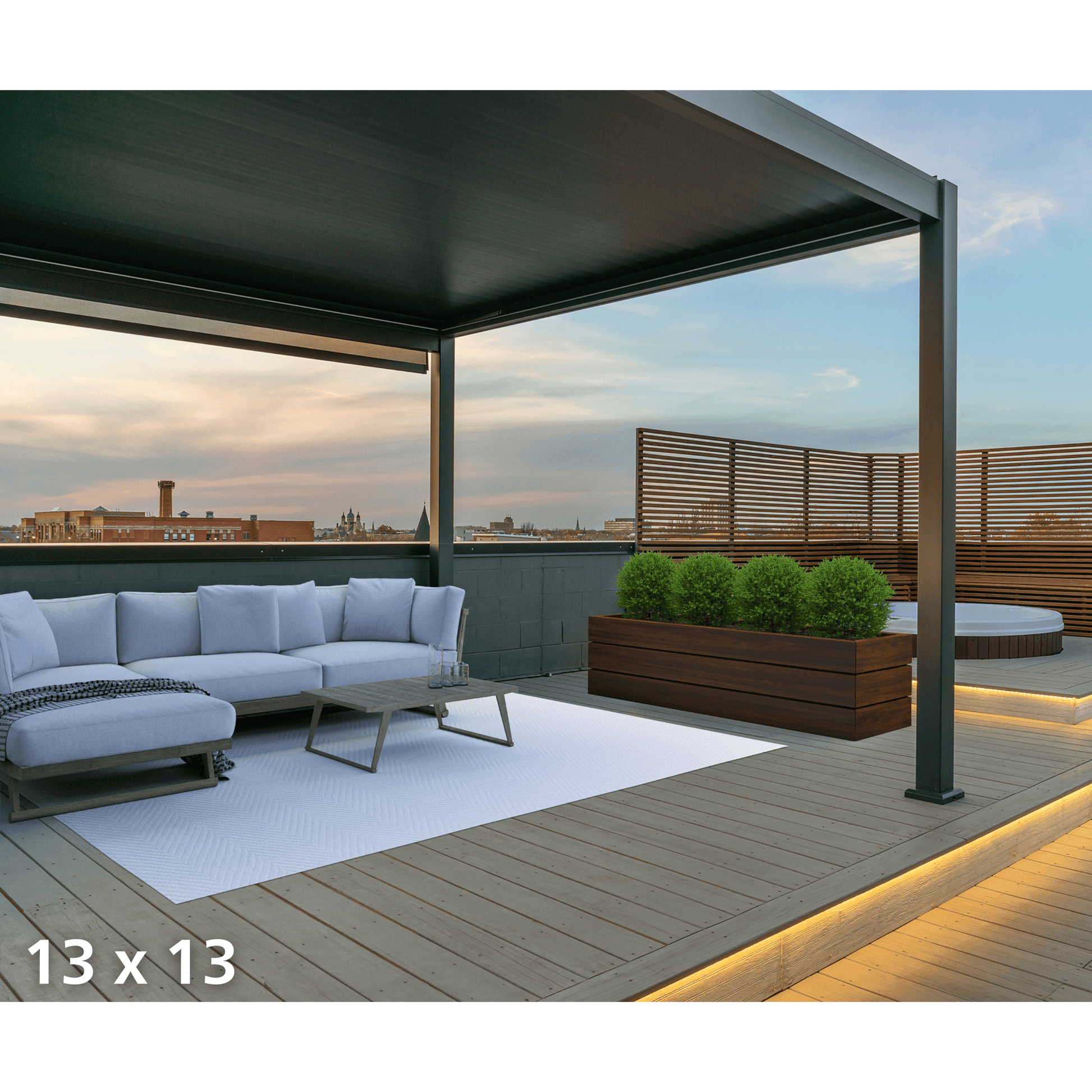 The dark gray Bon Pergola features fully closed louvers, creating a solid roof. Warm yellow LED light strips run along the edges, casting a soft glow onto the wooden deck below—turning this rooftop terrace into an inviting outdoor retreat.