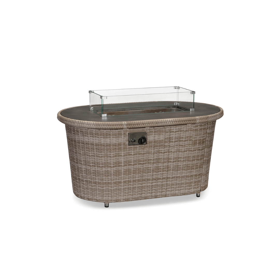 This product shot showcases the Orchard Collection Fire Pit. The coffee table is made from tightly woven brown rattan, with a rectangular gas fire pit area at the center, secured by a rectangular tempered glass wind guard. The rest of the tabletop is a deep brown. On the side of the table, there’s a metal control panel with two black knobs for controlling the gas fire pit. The bottom of the coffee table is supported by four short metal legs.
