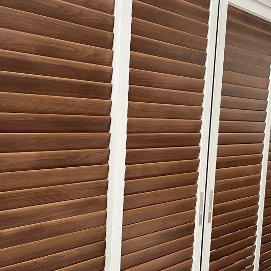 A section of the sliding blinds features white frames and deep brown horizontal slats. The gaps between the slats are smaller, providing better privacy and light blockage when fully closed. These blinds are commonly used to enclose balconies or patios, or as interior partitions, offering both aesthetic appeal and practicality.