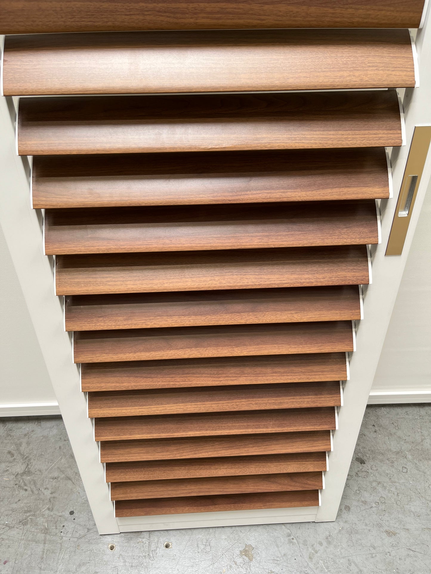 This blinds features white frames and deep brown horizontal slats. The slats are arranged evenly, showcasing a wood-like texture with a smooth, glossy finish. When fully closed, they provide enhanced privacy and light blocking.