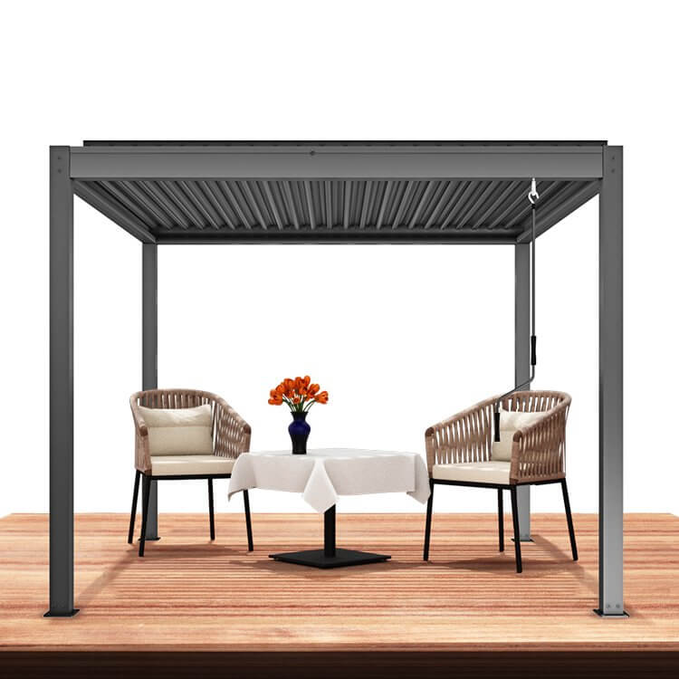 The dark gray Starry Pergola features a manual retractable sunshade, revealing part of its gray louvered structure. The pergola's frame is made of thick dark gray posts and beams, creating a sleek, modern design. On the right side of the pergola, a crank mechanism is visible, allowing for easy manual adjustment of the sunshade.