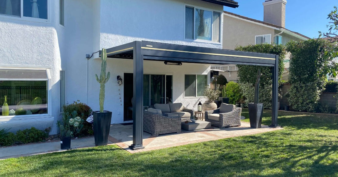 A large backyard with lush grass and an aluminum pergola on the side of a house, with potted cacti on the sides.