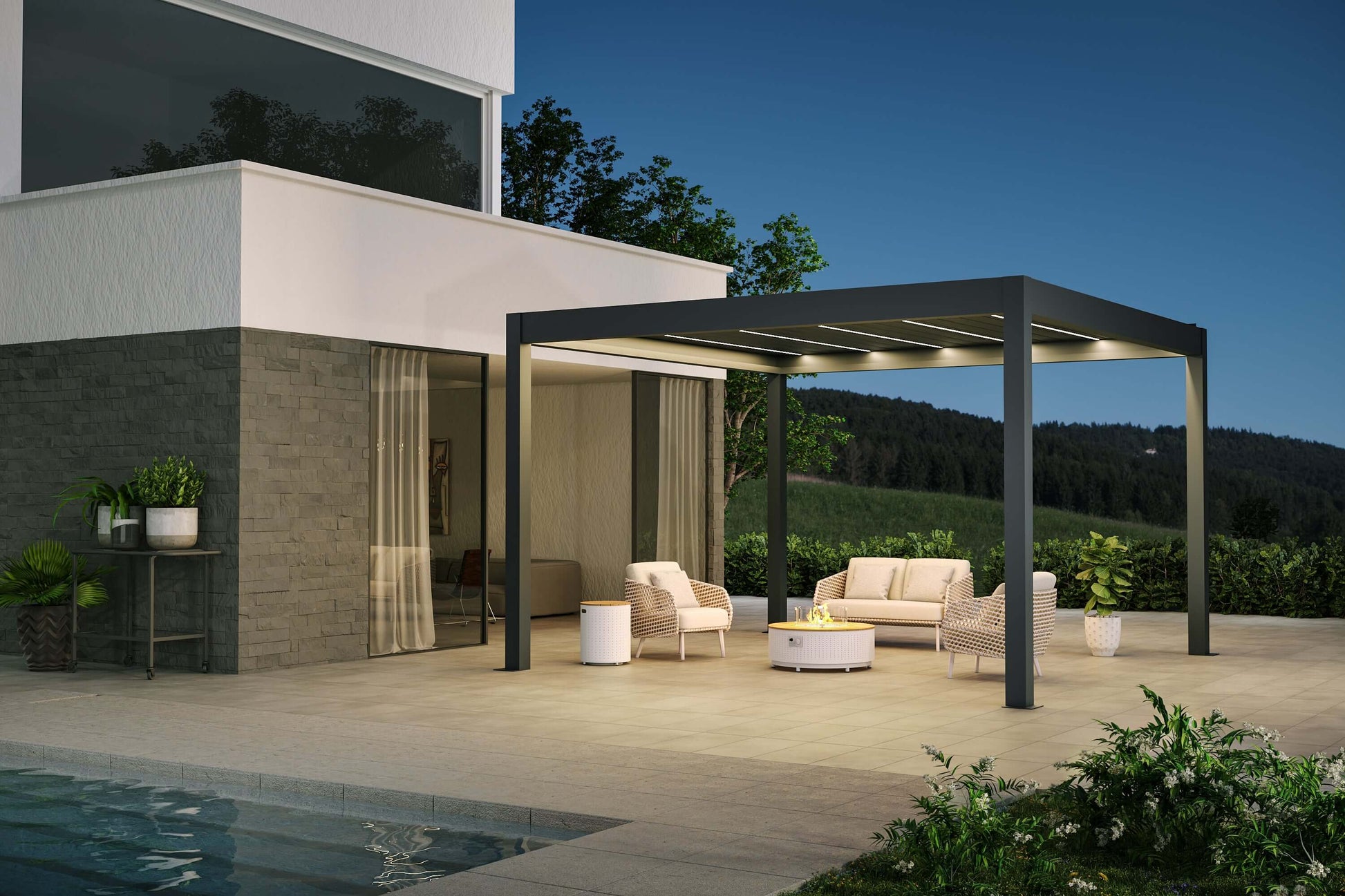 The top louvers of the pergola are open, with warm white LED strip lights installed between them. The structure is modern and minimalist, made of dark gray, sturdy columns and beams. Below, there's a beige and light brown outdoor lounge set, with a white round coffee table at the center. The coffee table features a gas fire pit in the middle, surrounded by a transparent glass wind guard. On one side of the loveseat, there’s a white cylindrical side table, adding a sleek touch to the seating area.
