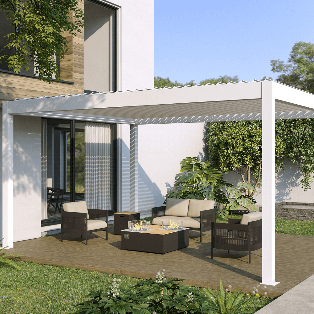 A white pergola with partially opened louvers lets sunlight filter through, creating a bright, airy vibe. The structure is supported by sleek white posts and beams. Below, a cozy outdoor lounge includes a beige two-seater sofa, two dark brown armchairs with beige cushions, and a matching dark brown square gas fire pit coffee table with a glass wind guard. A square wooden side table sits between the sofa and chairs, adding a warm touch to the space.