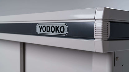 Close-up of a BON PERGOLA YODOKO Premium Outdoor Large Shed LMDS corner, featuring a sleek gray stripe and prominent brand logo. The modern industrial design reflects Japanese craftsmanship with clean lines and a smooth finish.