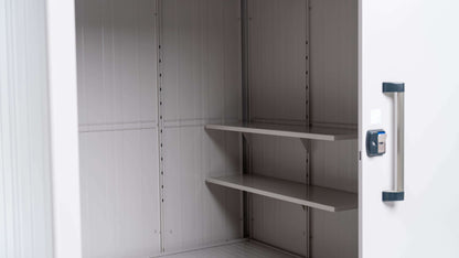 The YODOKO Premium Outdoor Large Shed LMDS by BON PERGOLA features an open design with sleek handles, showcasing Japanese craftsmanship. Inside, two metal shelves mount against a minimalist light gray interior, combining functionality and elegance.