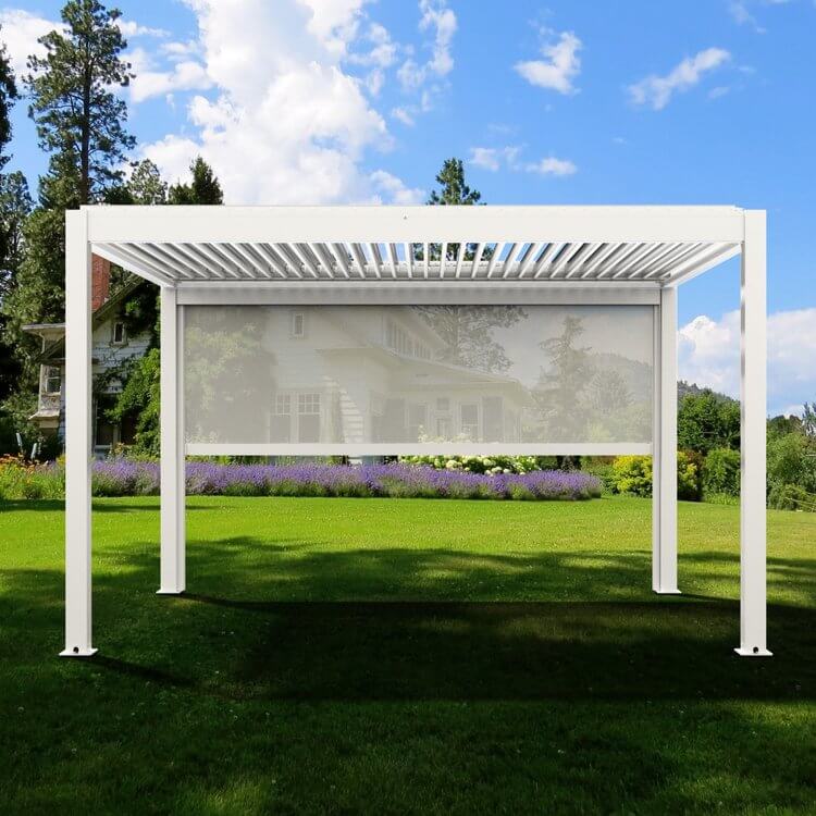 The white Bon Pergola 10x13 motorized louvered pergola features a clean, modern design with sturdy white posts and beams. The partially open louvers cast sleek, linear shadows across the outdoor space. On one side, a light gray Bon Pergola Wind Resistant Screen for Villa Pergola SCN is partially lowered, offering gentle shade and added privacy.