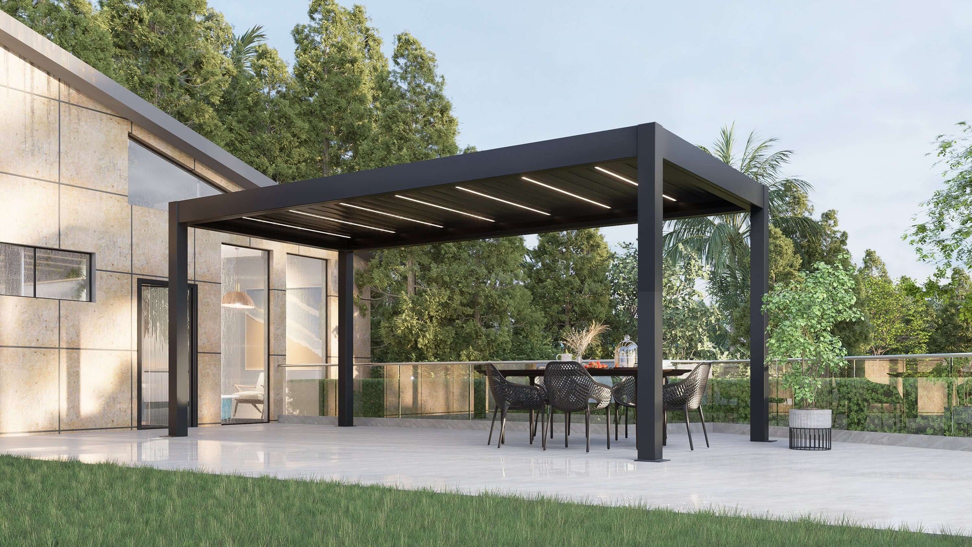 A dark gray Bon Pergola with a motorized louvered roof and integrated LED lighting sits on a light gray paved patio, next to a modern light-colored building. Surrounded by green trees and lawn, the pergola features deep gray louvers with built-in white LED light strips, visible even during the day. Its sturdy posts and beams create a clean, contemporary look, blending style and function in an elegant outdoor setting.